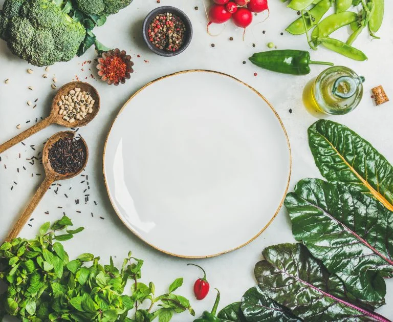 Empty plate surrounded by healthy foods.