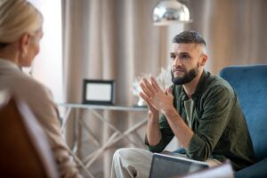 Man listening to psychologist during a mental health counseling session