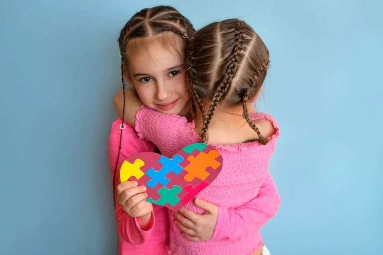 The child presented a puzzle card to his friend with an autism spectrum disorder. Care , support and assistance to children with disabilities