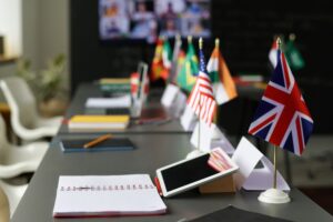 Close-up of table with flags of different countries on it in the classroom at school SSUCv3H4sIAAAAAAAACpxSy27jMAy8L7D/EOi8BuS33V9Z7IGS6FiobBmS3KII8u+VH0oY9LY3c4Yajsm5/f51uTABXkv2drltVay1MasPDoK2c4T5nxN3OCt0FPlwZcMpAJpWqHSwToOhoIAgxxkmjOC8GrPB951kPkBYPXriZXCIi36PSJ4E/LiGgM4HK19w5RAmH/Su/ERxsV6HZbTBekosdlY1BcDA9LUBxJGEgNf4Cy+e0r7+HvUlETsZX0SKsVP1cLyKHUvQIf5fL4+Pfw/PV5zlZvp2J64dGoRjj6dH1nBeyULIbBBQZBW0RSZkC1lRQKug76qirdJkJpWoSylVlndbs8I669oKMuRNiTUoqITYLR0+2PtnvMe0r+h0AKvSlqzsw0owW0NJbIJewMHLu8VpqecrQWwY98wlJWnXObgvuilmrF1AmO3uQxyDCR/B+9iuEk4PGxNuJzJntmFf2KnKVLz8VuZlWZU177q8r3rO67xjNKyjjjq7nWRwXYwFhdvQx3VpjJu+51GyrR53/pHooyUOfba8hvtsqInGj5yfPU3KN438ybXtk3uk/+T6/qBornaDWtGD6e0/GaDohSwgq3mvYrqUzLpBiKwAUcpBls3AMQbm/g0AAP//AwAXNtzPcAQAAA==