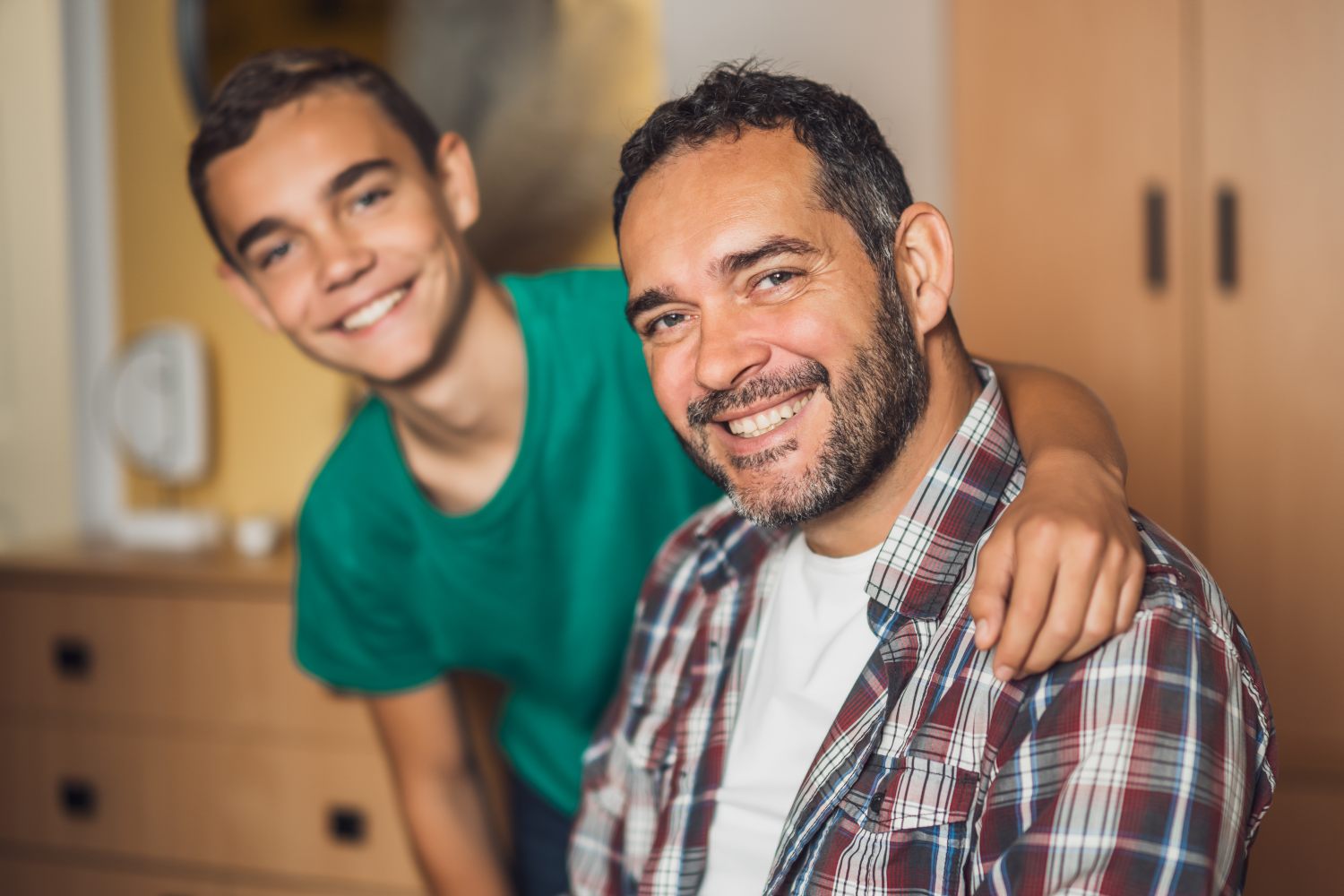 smiling father and son, concept of parental support through teenage mental health struggles