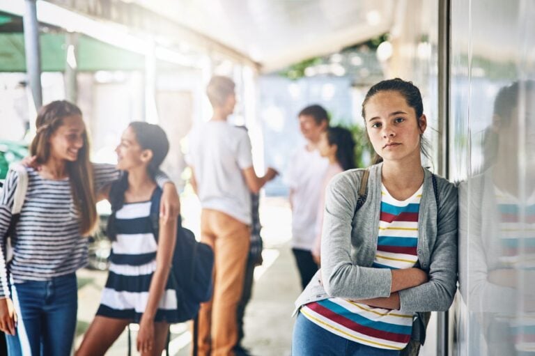 teenage girl standing by the school corridor, alone and isolation concept