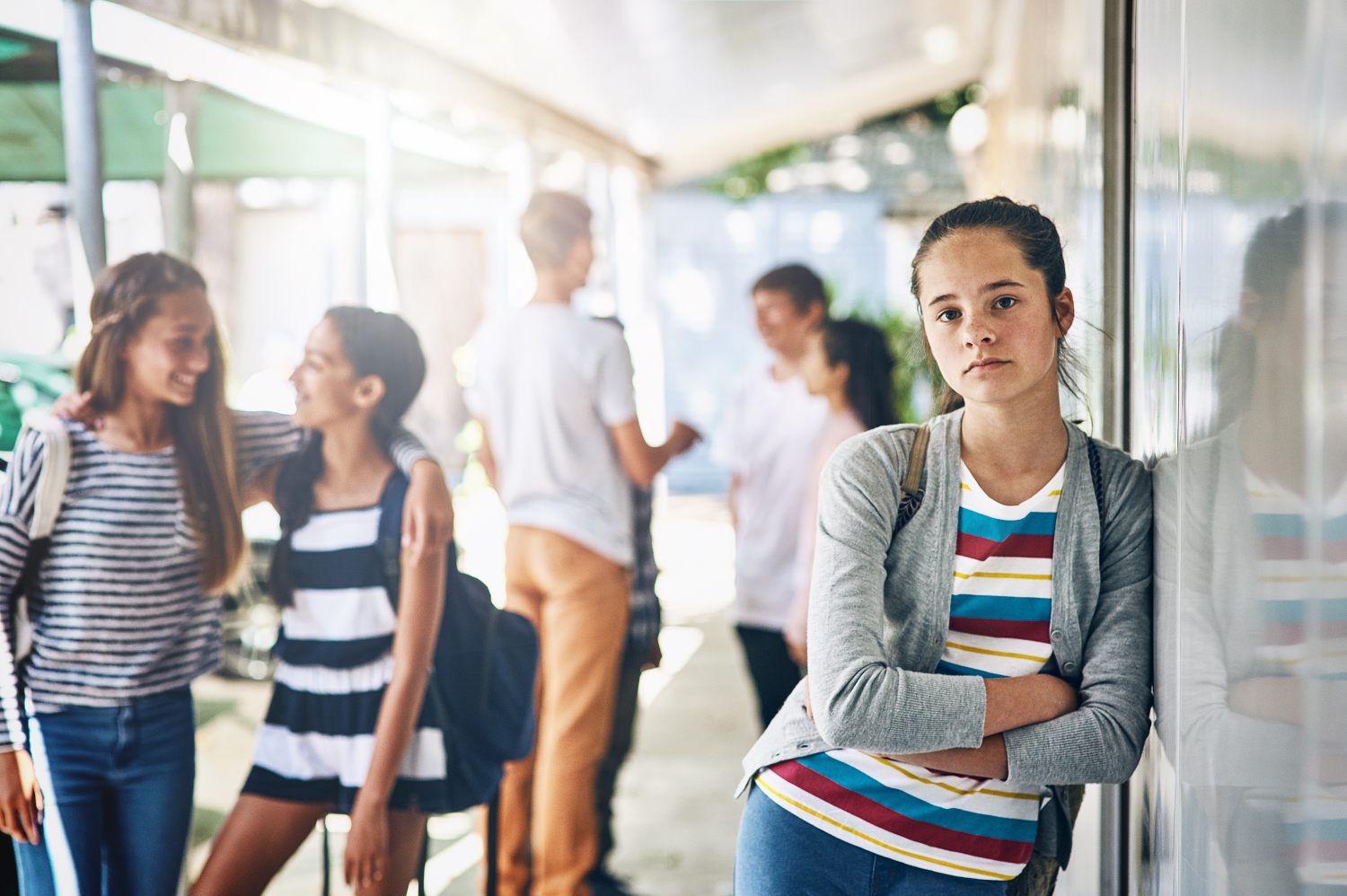 teenage girl standing by the school corridor, alone and isolation concept