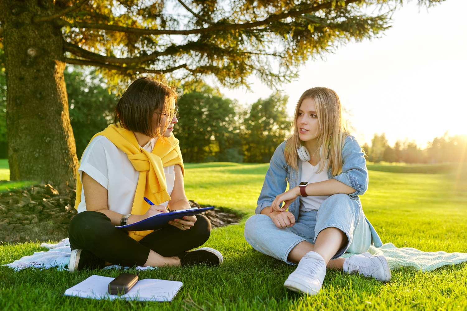 counsellor and teenage girl having a therapy session outdoors