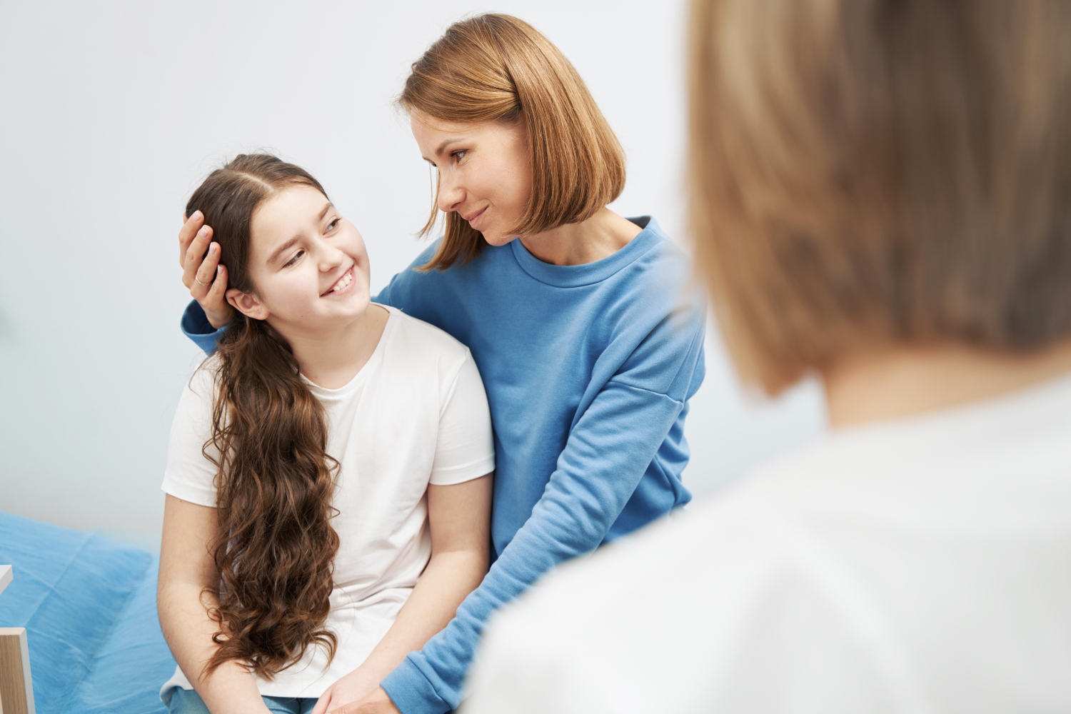 young girl hugging mother during counseling session