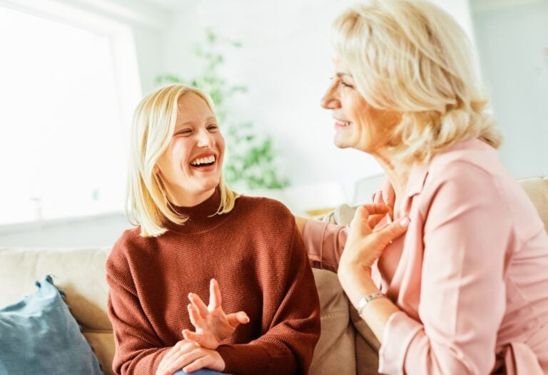 mother and teenage daughter smiling and happily talking to each other