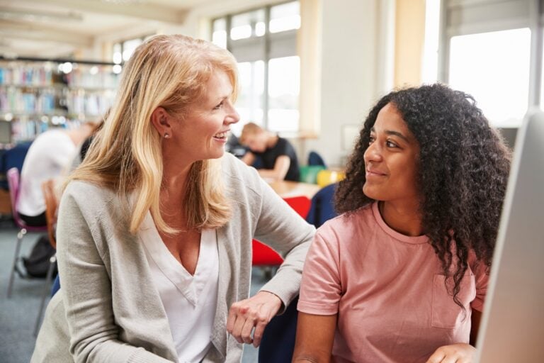 therapist looking at and smiling at a female teenager, concept of counseling, therapy