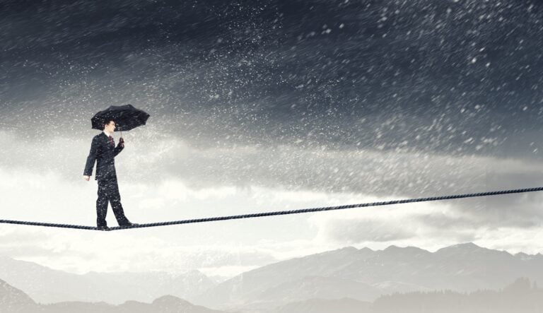 image of a businessman standing and crossing a tight rope, concept of mental health and business