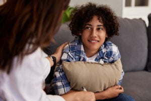 smiling teenager talking to therapist