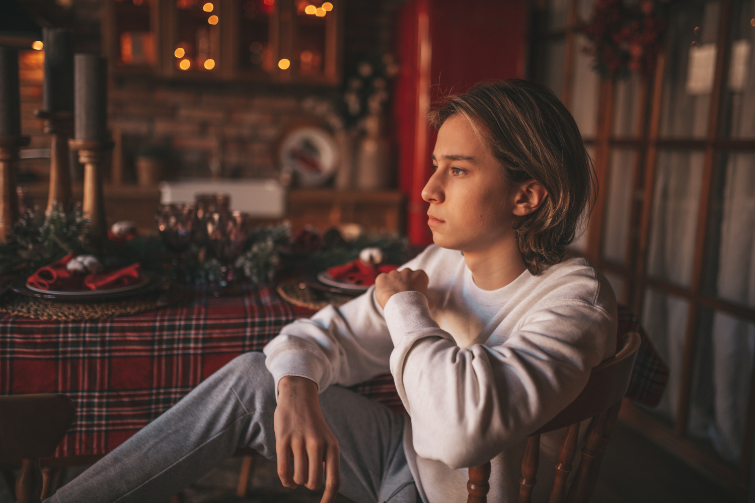 image of a teenage boy looking sad at home during holiday celebrations