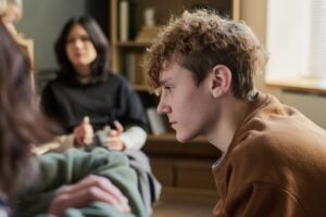 Teenage Boy Listening Attentively during Group Therapy Session