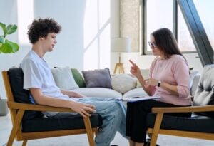 teenager talking to a counselor or therapist, concept of mental health treatment