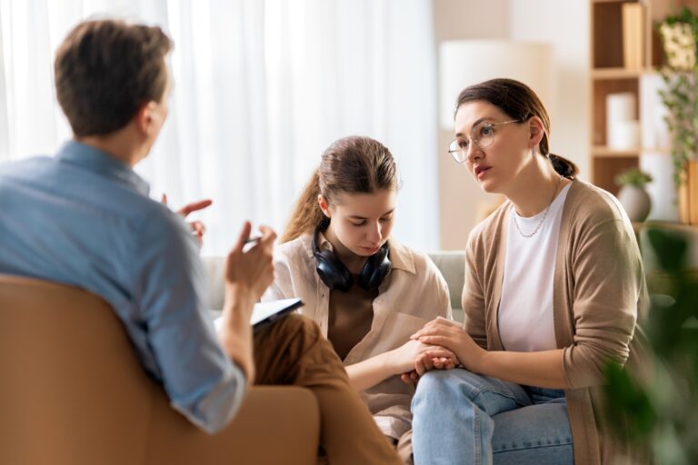 mom and teenage daughter speaking with a counselor