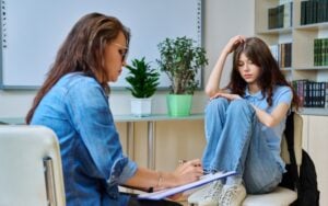 teenage girl in mental therapy session, talking with school counsellor