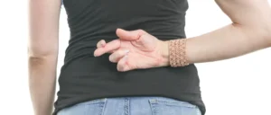 Woman crossing fingers with hand behind her back